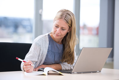 Freiberufliche Pflegegutachterin arbeitet am Laptop