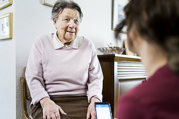 Pflegegutachterin des Medizinischen Dienstes begutachtet eine alte Dame