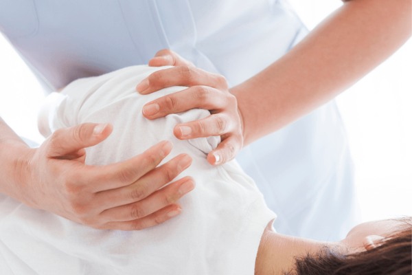 Darstellung einer Reha-Ma&szlig;nahme: therapeutische Behandlung der Schulter in liegender Position.