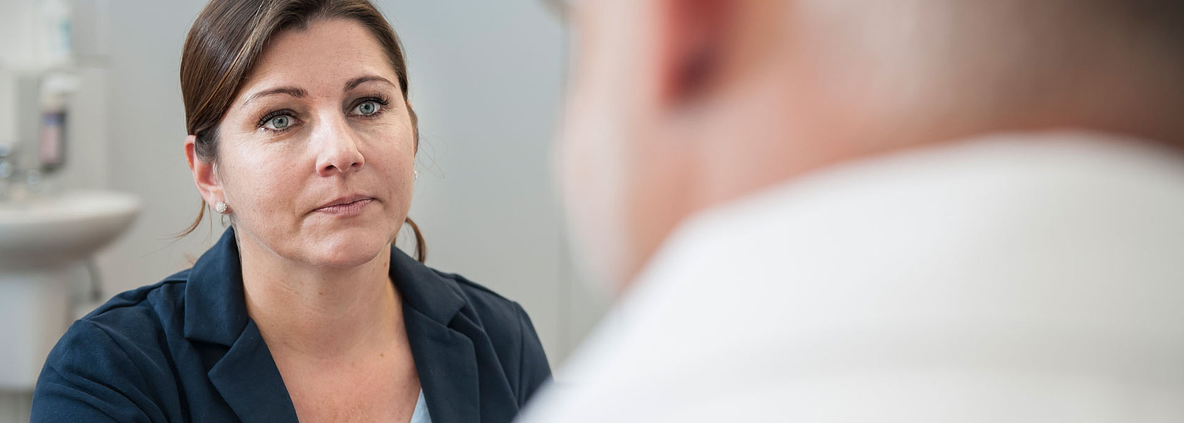 Eine Fachkraft führt ein Beratungsgespräch mit einem Patienten zum möglichen Off-Label-Einsatz eines Medikaments.